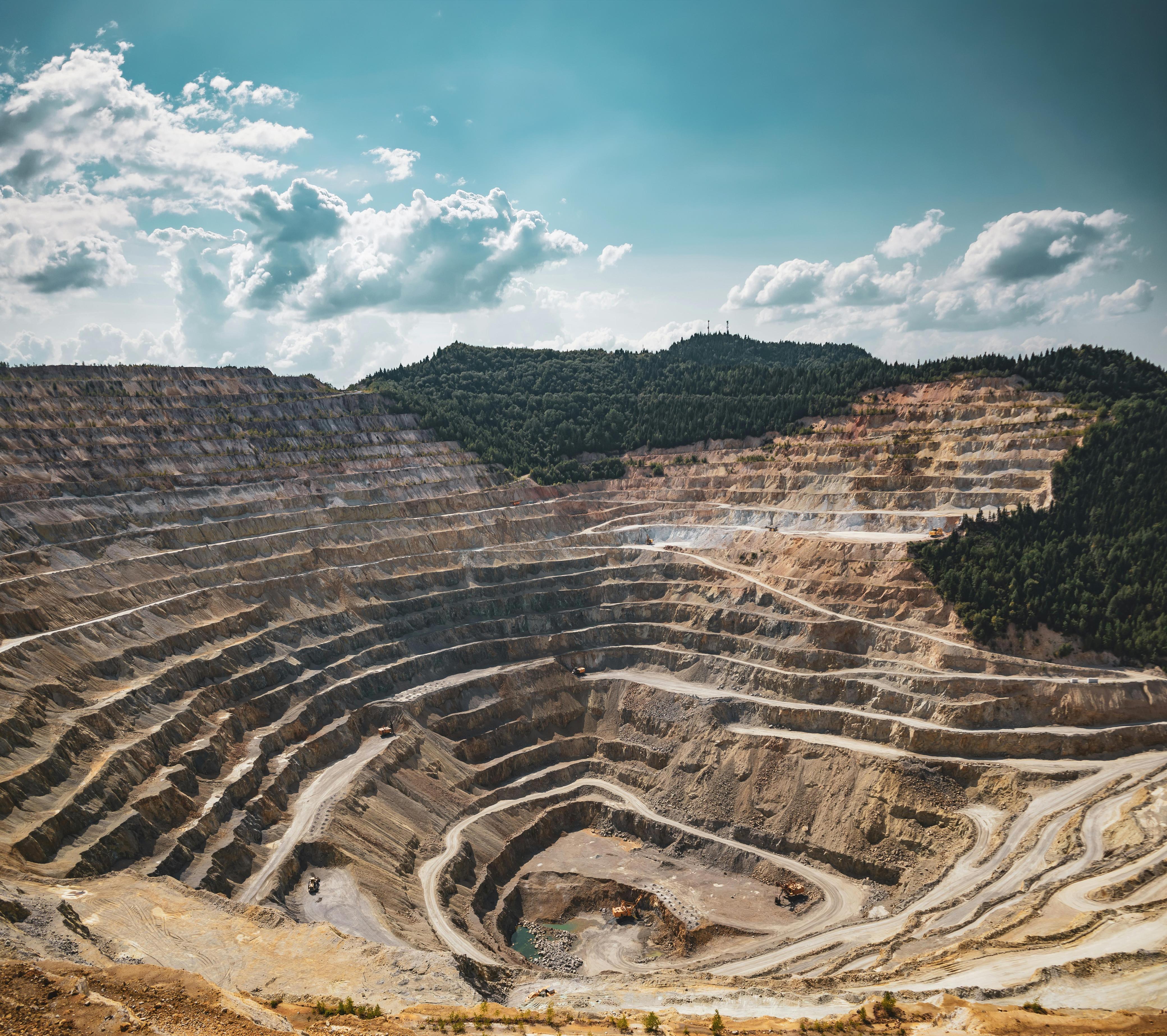 Large mining operation with heavy equipment and excavated terrain